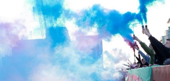 Activists let off smoke bombs in the trans flag colours in protest of the government's treatment of trans people.