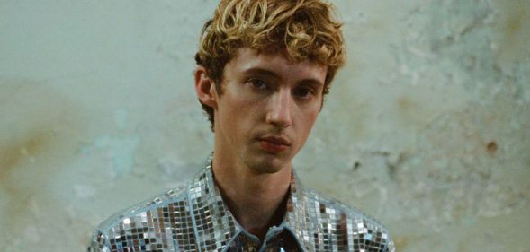 Troye Sivan in a silver top.