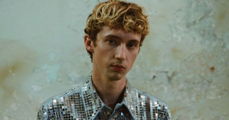 Troye Sivan in a silver top.