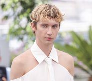 Troye Sivan in a white shoulder-less shirt.