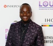 Will Njobvu in a patterned black and purple suit.