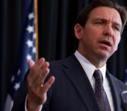 A picture of Florida governor Ron DeSantis, who championed a drag ban law in the state, wearing a suit and tie as he speaks to a crowd off camera