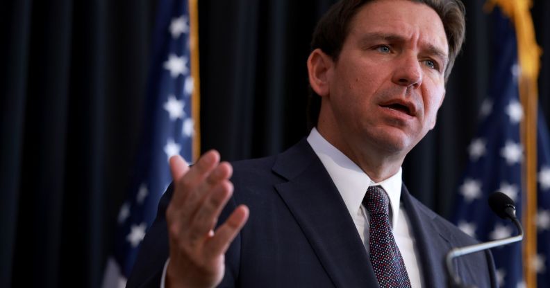 A picture of Florida governor Ron DeSantis, who championed a drag ban law in the state, wearing a suit and tie as he speaks to a crowd off camera