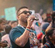 Navonil Das, an LGBTQ+ activist from India, pictured speaking into a microphone at a demonstration.