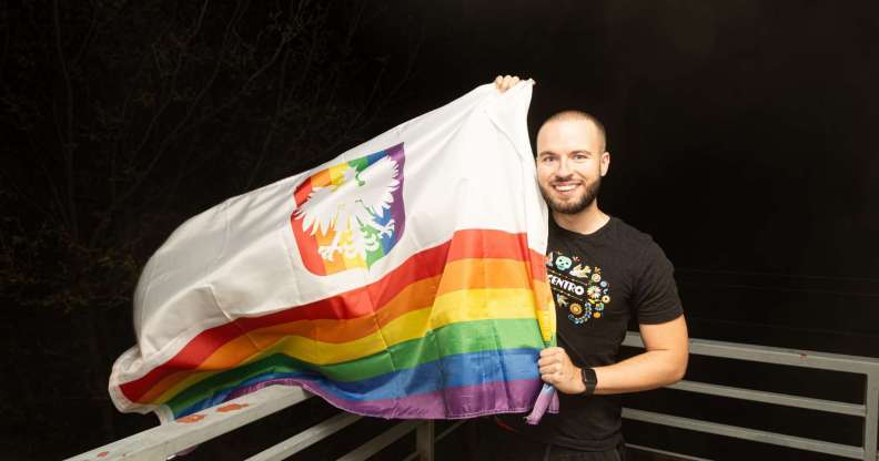 Bart Staszewski pictured holding a Pride flag outside after the election in Poland.