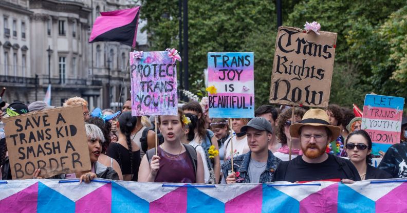 Various people hold up signs calling for trans youth and adults to be protected amid repeated attacks on healthcare rights, closure of gender identity services in England and more in the UK