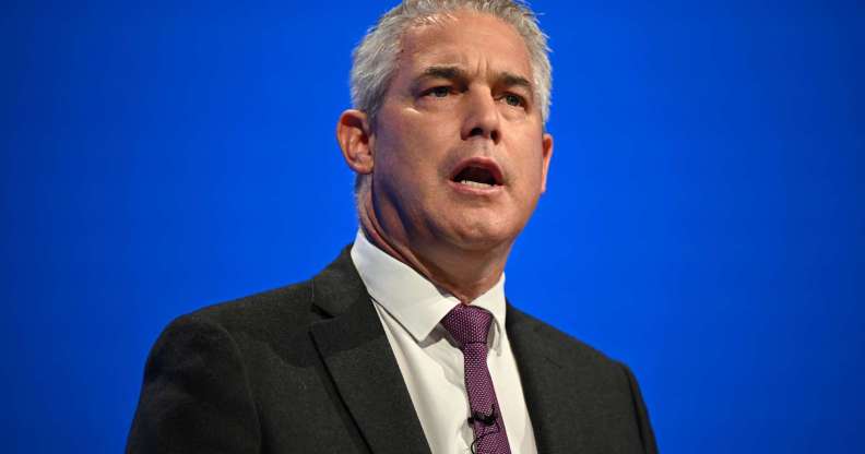 Steve Barclay giving a speech at the Conservative party conference in Manchester in October 2023. He is pictured wearing a dark suit and tie against a blue background.