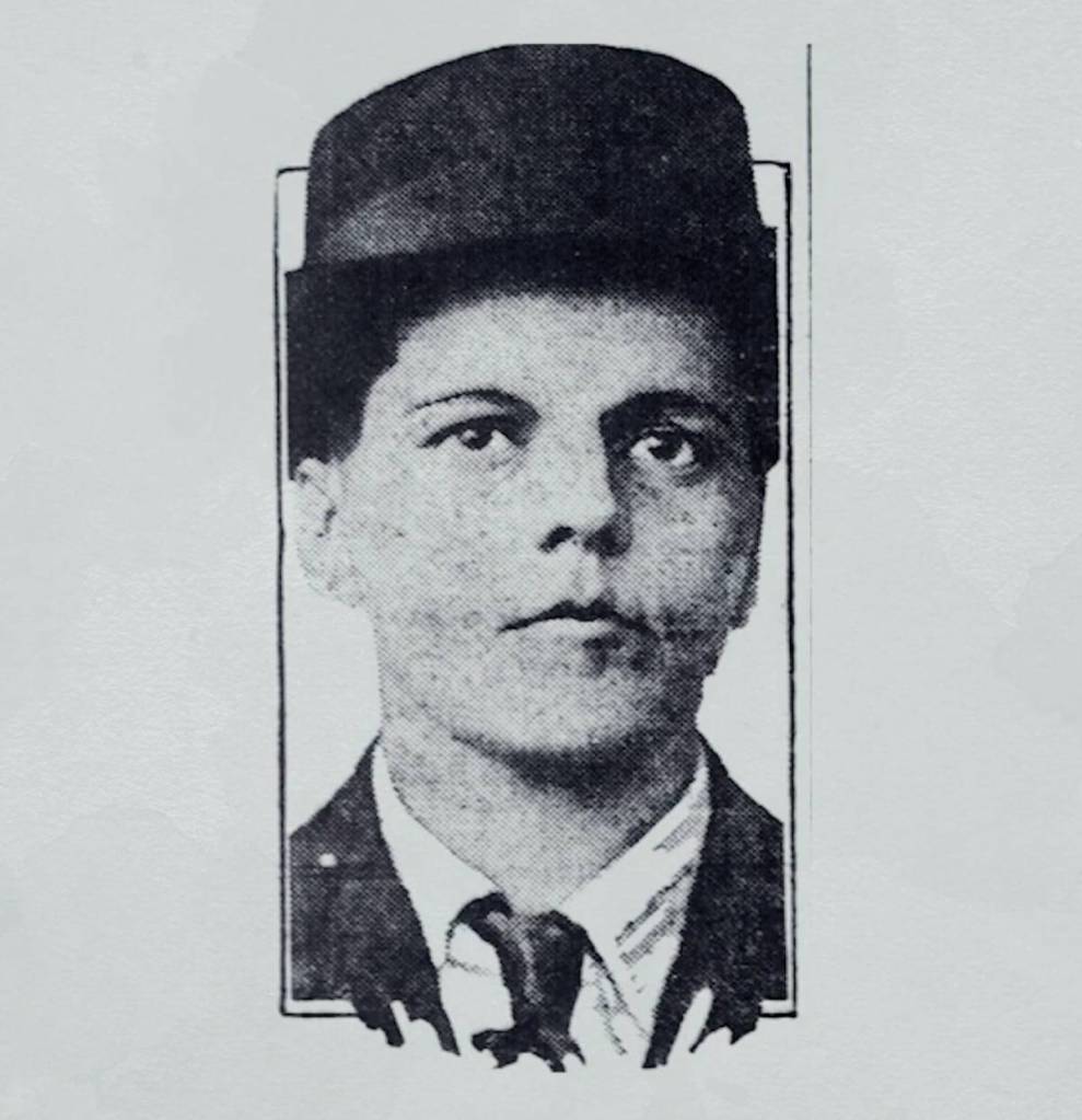 A black and white photo of Harry Allen, a trans man, wearing a suit and tie with a bowler hat
