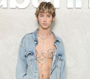 Australian singer Troye Sivan wears sparkly body jewellery on his bare chest and a light denim jacket