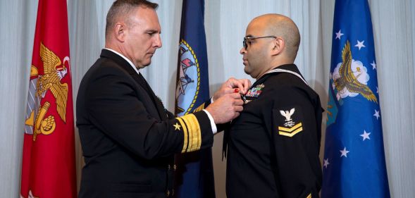 Information Technician 2nd Class Thomas James wears a Naval uniform as a medal is pinned to his chest in a ceremony honouring his brave actions on the night of the Club Q shooting in November 2022
