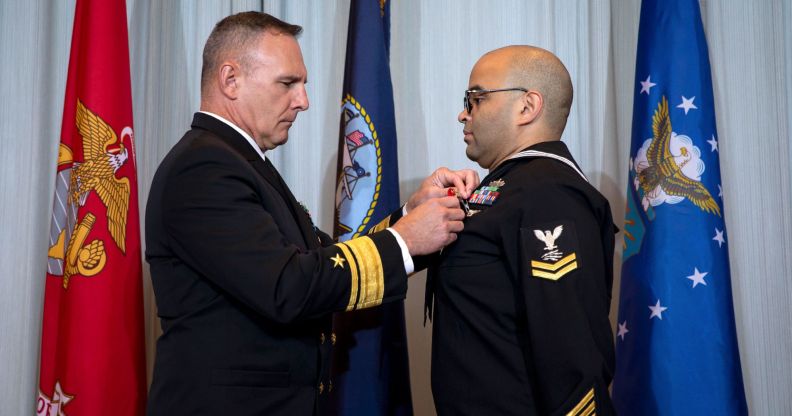 Information Technician 2nd Class Thomas James wears a Naval uniform as a medal is pinned to his chest in a ceremony honouring his brave actions on the night of the Club Q shooting in November 2022