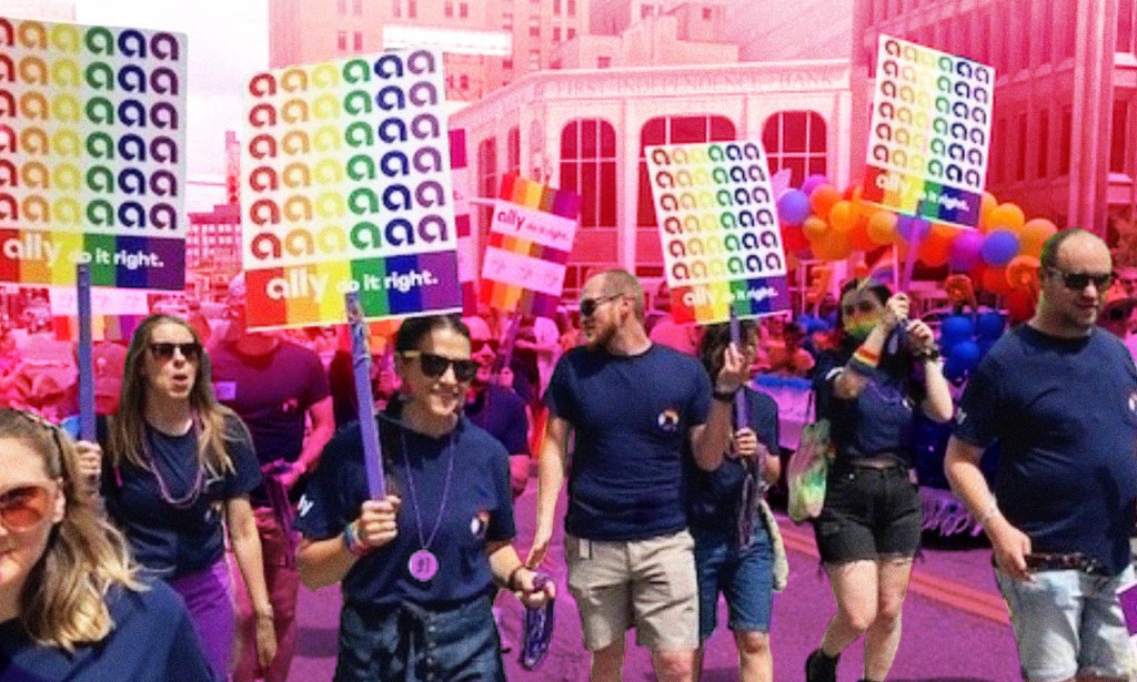 This is a creative image of employees of Ally Financial at a Pride march. There is a pinkish hue over the top of their placards.