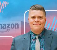 This is a picture of a trans man. He is wearing a bluish grey suit. In the background there is a logo of Amazon with a creative overlay using the colours of the trans flag, pink, white and blue