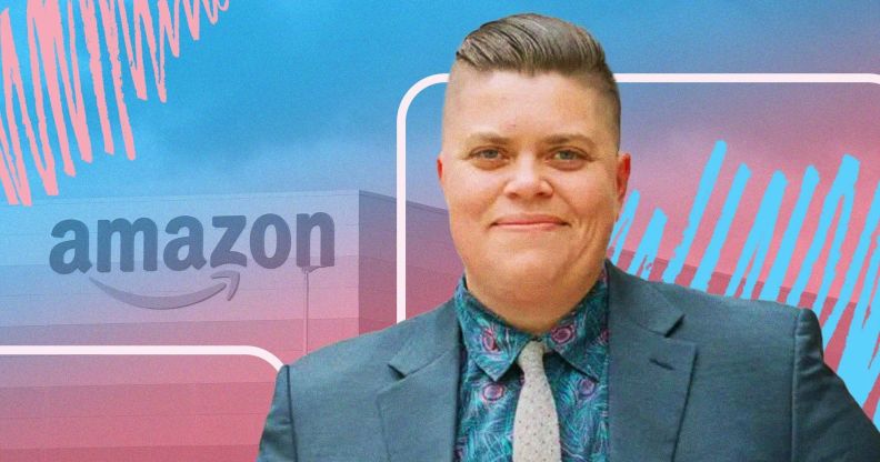 This is a picture of a trans man. He is wearing a bluish grey suit. In the background there is a logo of Amazon with a creative overlay using the colours of the trans flag, pink, white and blue