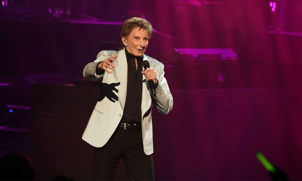 Singer Barry Manilow holds microphone on stage