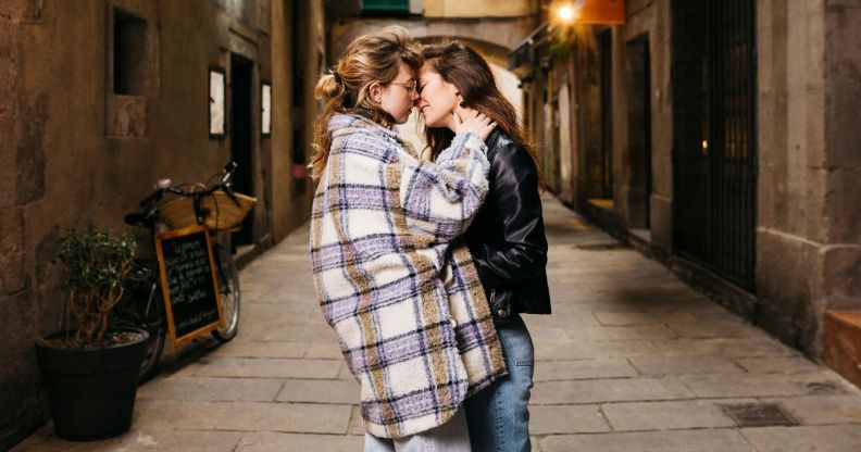 Stock image of two women kisses on an alley street