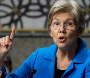 Elizabeth Warren raises a finger to enunciate a point while speaking.
