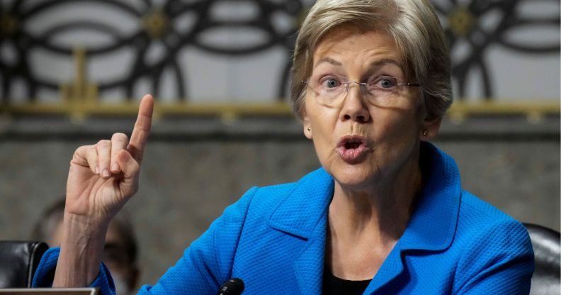 Elizabeth Warren raises a finger to enunciate a point while speaking.