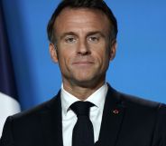 Emmanuel Macron looking directly forward on a blue set.