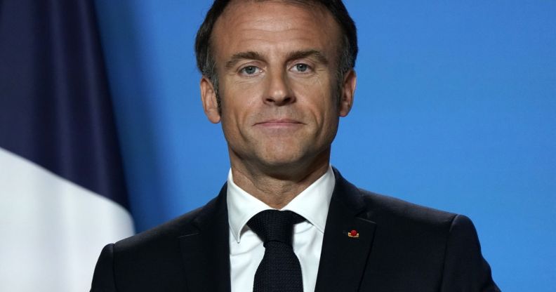 Emmanuel Macron looking directly forward on a blue set.