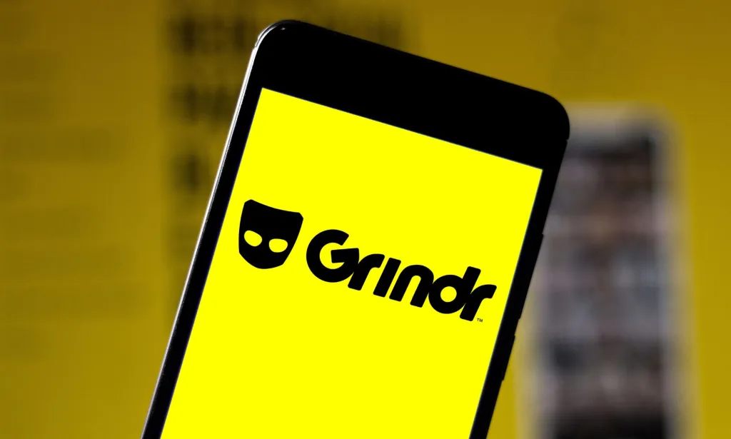 A phone with the logo of Grindr on it.