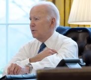Joe Biden rolling up his sleeves whilst sat at the White House desk.