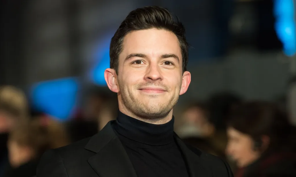 Jonathan Bailey in a black roll-neck and blazer.