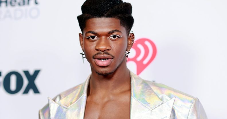 Lil Nas X topless and in a silver jacket.