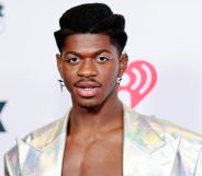 Lil Nas X topless and in a silver jacket.