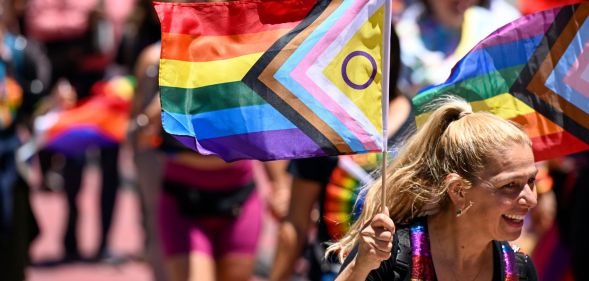 Woman carries an inclusive Pride flag during San Francisco Pride march in June 2022