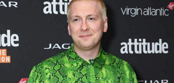 Comedian Joe Lycett, who has used his platform to troll various politicians including Suella Braverman, smiles as he wears a green and black snakeskin patterned top