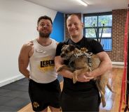 Daniel Browne and Chris Woods of the Leeds People's Gym pictured in their gym posing with a dog.