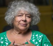 Actor Miriam Margoyles wears a green shirt with while spots on it while her hands cover her chest over her heart