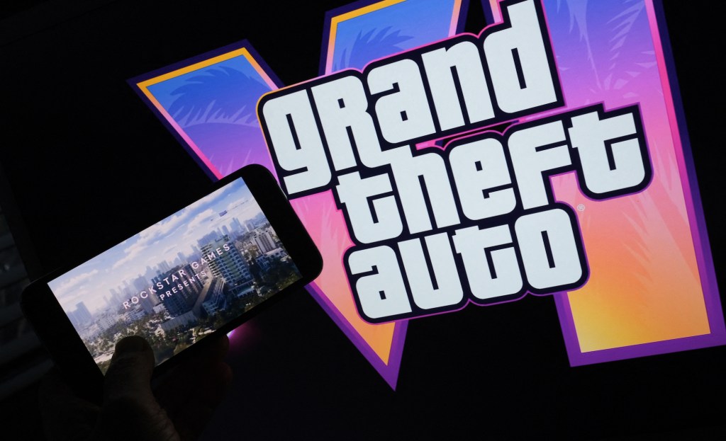 This illustration photo created in Los Angeles, December 4, 2023, shows Rockstar Games’ Grand Theft Auto VI trailer played on a screen in front of the game title. The first trailer for "Grand Theft Auto VI" was officially released ahead of schedule December 4, 2023 due to a leak, touting a 2025 release for the next chapter of the massively successful video game franchise. (Photo by Chris DELMAS / AFP)
