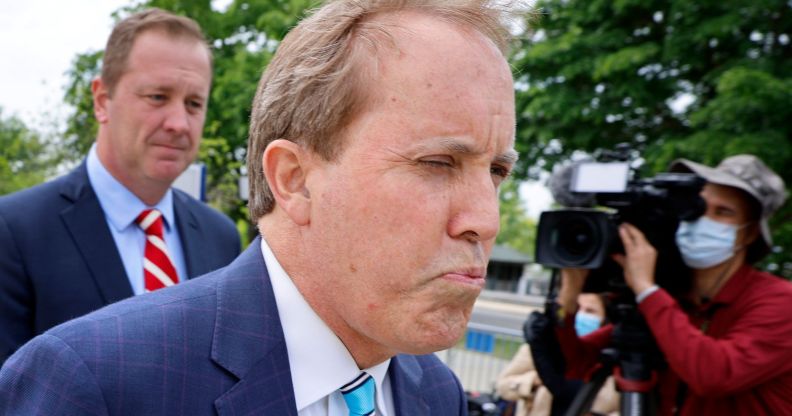 Ken Paxton, pictured walking away from press.