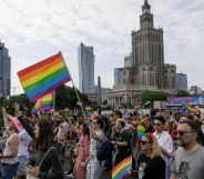 People march through the street with rainbow flags during the Warsaw Equality Parade in Poland in 2023