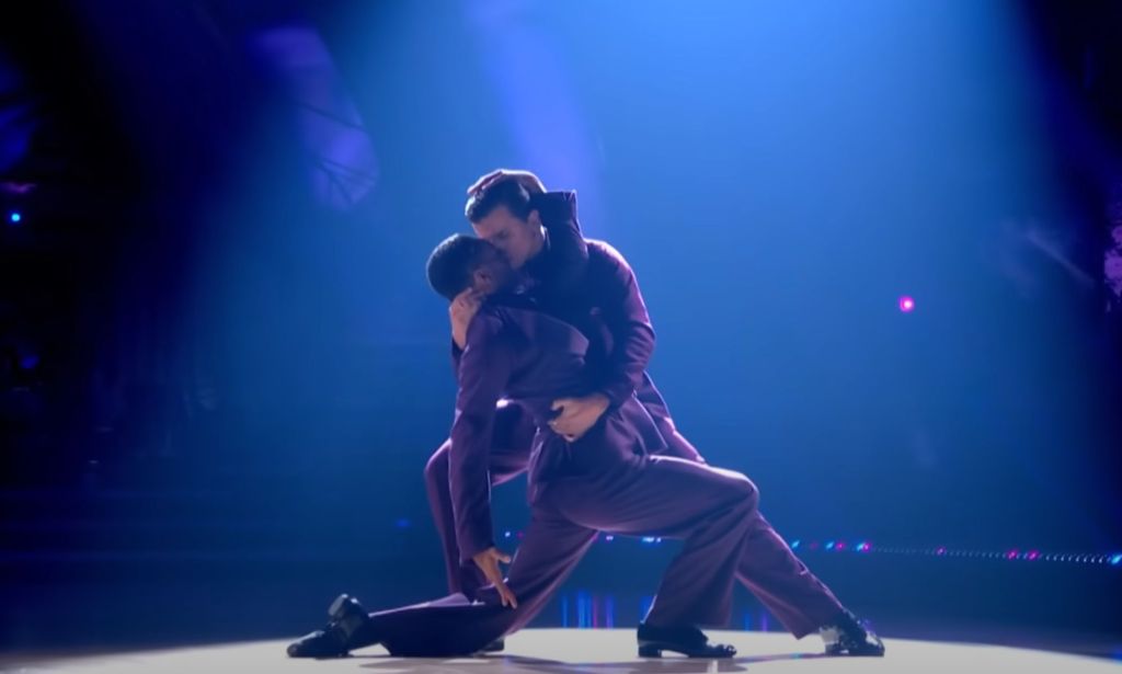 Layton Williams and Nikita Kuzmin wear matching purple outfits as they hold each other close and dance together during a performance on BBC's Strictly Come Dancing