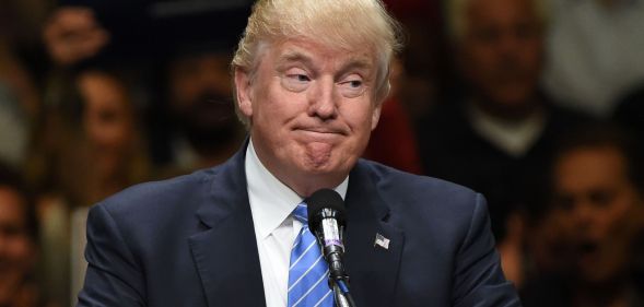 President Donald Trump, who has been taken off the Colorado primary ballot after a ruling by the state's supreme court, wears a suit and tie while speaking at a podium