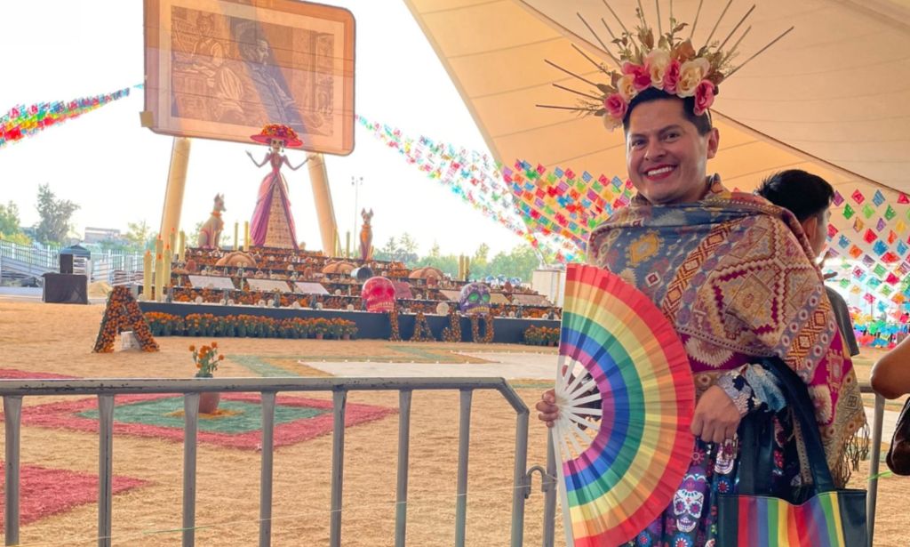 Jesús Ociel Baena wears colourful skirt and top as they pose with a rainbow LGBTQ+ handfan. They are among the LGBTQ+ celebs, changemakers and allies that died in 2023