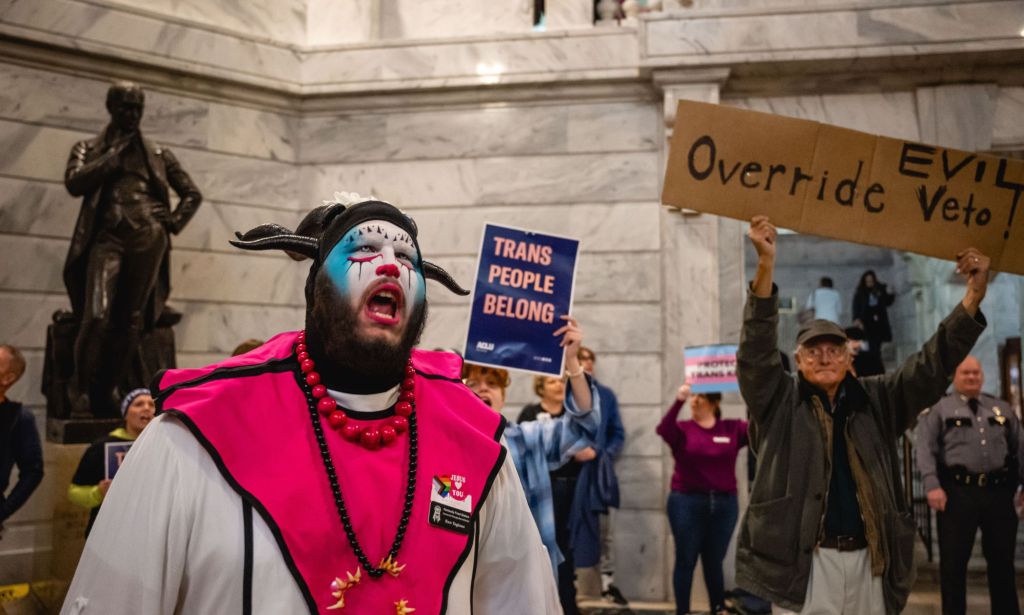 A person wearing blue and white facepaint shouts as LGBTQ+ people and allies gather in protest against an anti-trans bill in the state of Kentucky