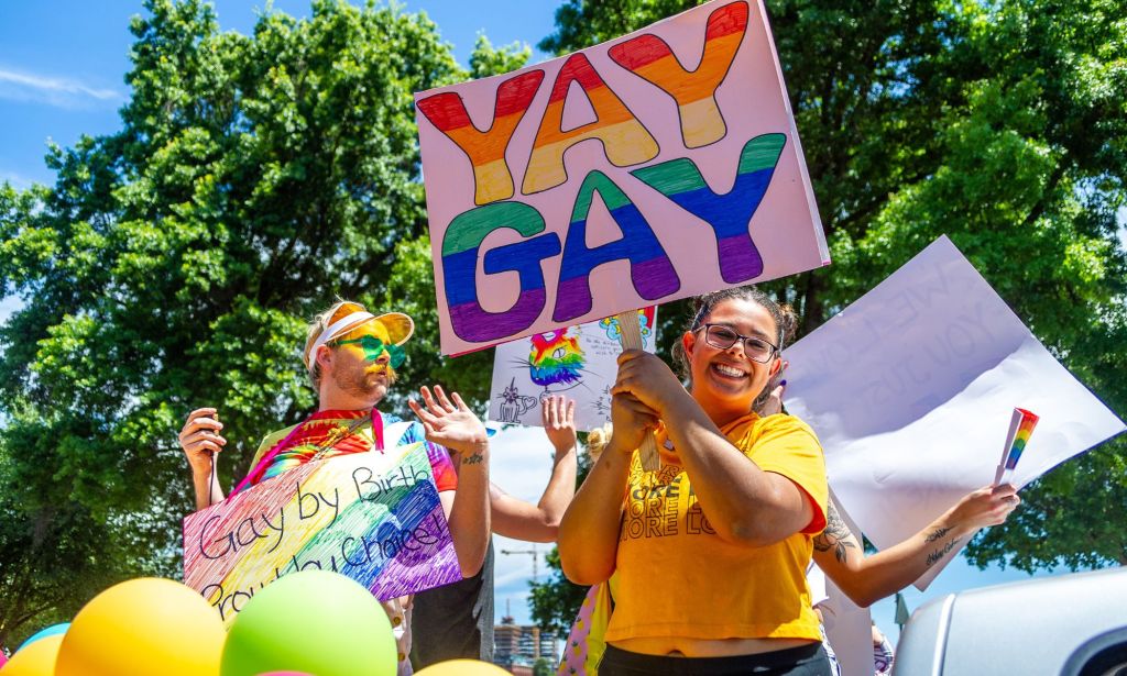 A person holds up a sign reading 'yay gay' in rainbow lettering during an LGBTQ+ pride celebration in the US state of Oregon