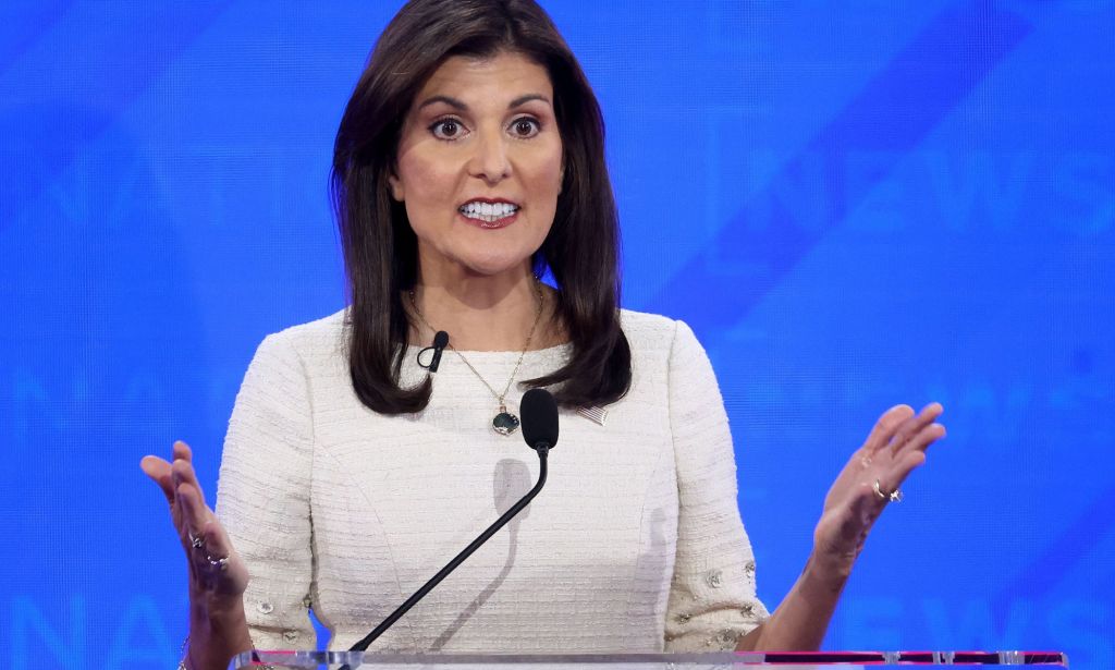 GOP presidential hopeful Nikki Haley wears white dress as she stands at a podium for the Republican debate, where she made several anti-trans statements