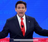 GOP presidential hopeful Ron DeSantis wears a suit and tie as he stands at a podium for the Republican debate, where he made several anti-trans statements