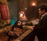 A still from What We Do in the Shadows with vampire character Nandor in a coffin with human familiar Guillermo talking to him