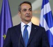 Kyriakos Mitsotakis infront of a Greece and European Union flag.