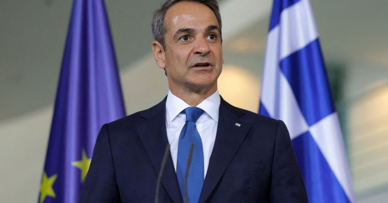 Kyriakos Mitsotakis infront of a Greece and European Union flag.