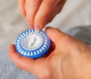 A person picks a pill out of a HRT capsule.
