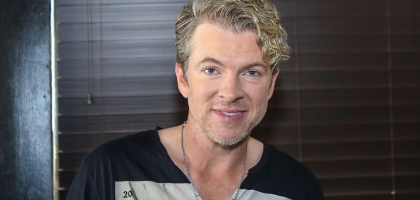 Joe Don Rooney smiling in a black and grey top.