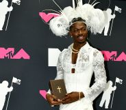 Lil Nas X poses with a bible in the press room at the 2023 MTV Video Music Awards