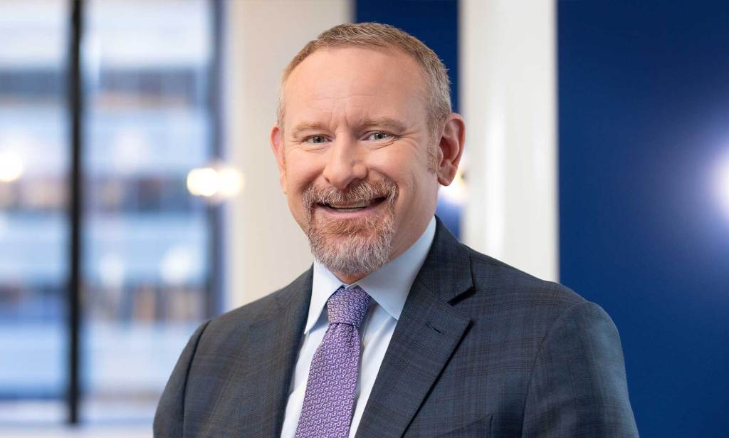 This is an image of a man. He is white, has a short goatee beard and close cropped brown hair. He is smiling at the camera.